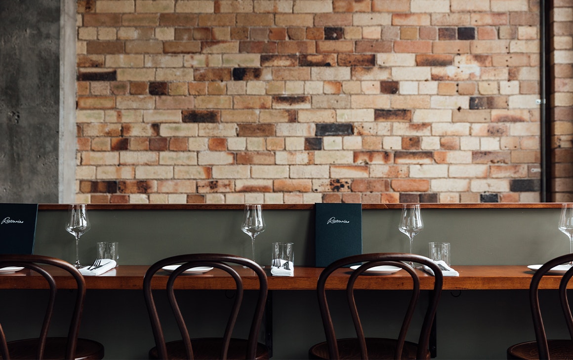 bar seating in front of a brick wall